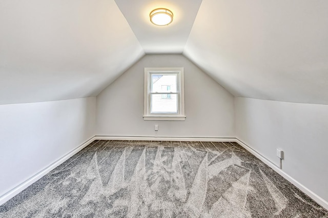 additional living space featuring vaulted ceiling and carpet