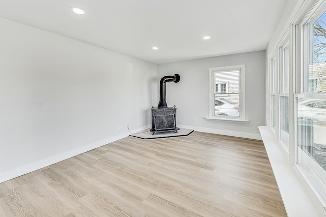 unfurnished living room with light hardwood / wood-style flooring and a wood stove