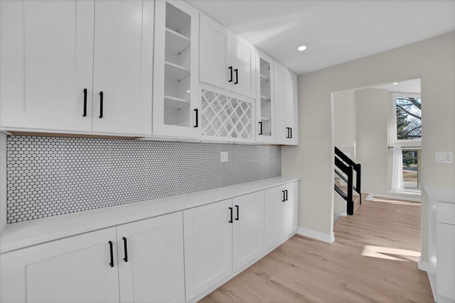 kitchen featuring backsplash, white cabinets, and light wood-type flooring