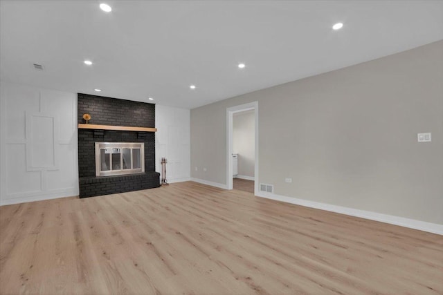 unfurnished living room featuring a fireplace and light wood-type flooring