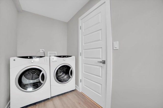 laundry area featuring separate washer and dryer and light hardwood / wood-style floors