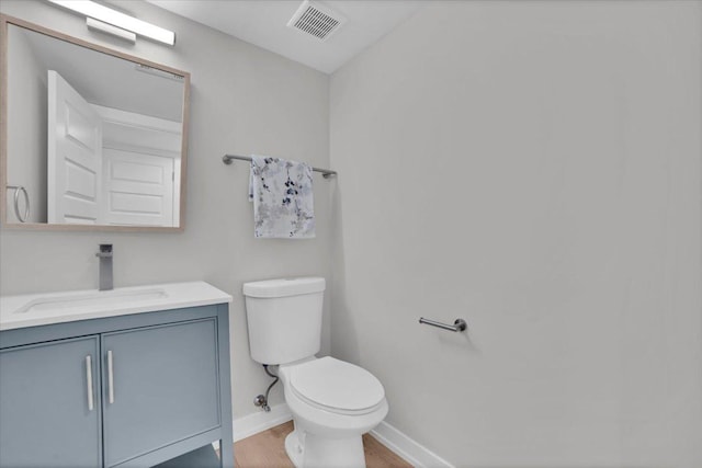 bathroom featuring vanity, toilet, and hardwood / wood-style floors