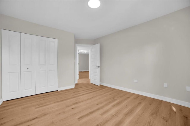 unfurnished bedroom with light hardwood / wood-style floors and a closet