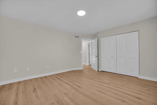 unfurnished bedroom featuring light wood-type flooring and a closet