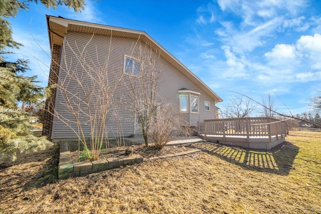 rear view of property featuring a yard and a deck