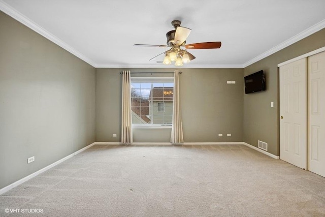 unfurnished bedroom featuring light carpet, ornamental molding, a closet, and ceiling fan