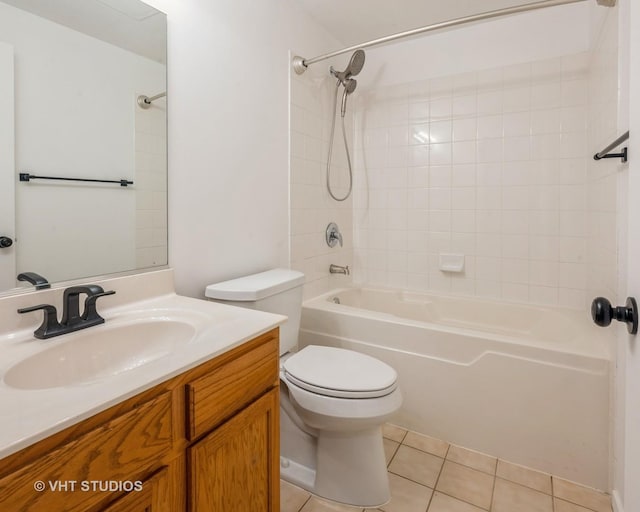 full bathroom with tile patterned flooring, vanity, tiled shower / bath, and toilet