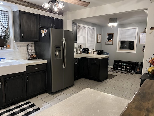 kitchen with light tile patterned flooring, sink, stainless steel fridge, and decorative backsplash