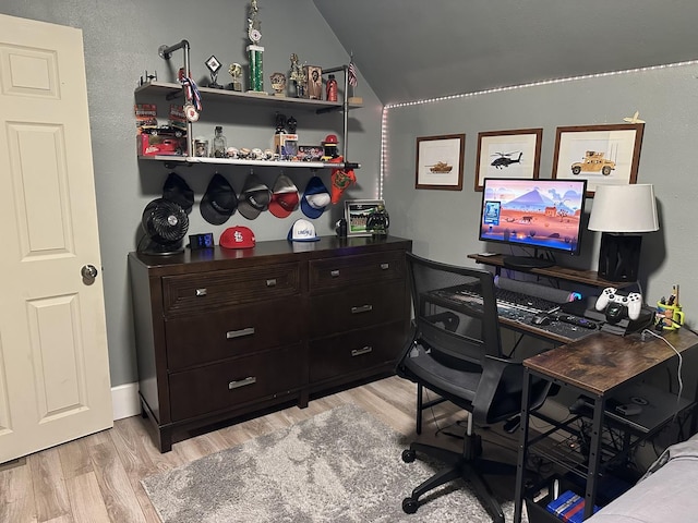 home office with lofted ceiling and light hardwood / wood-style flooring