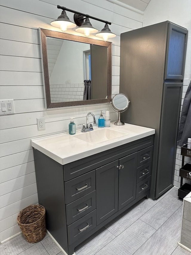 bathroom with vanity and wood walls