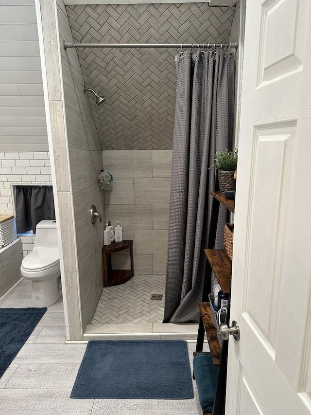 bathroom featuring a shower with curtain, tile patterned floors, and toilet