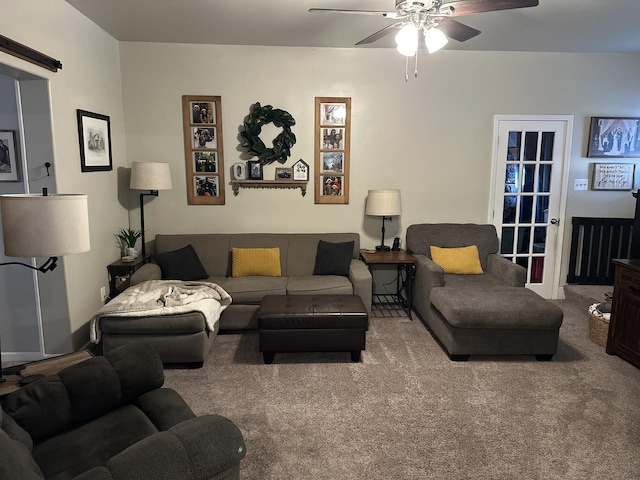 living room with ceiling fan, carpet flooring, and a barn door