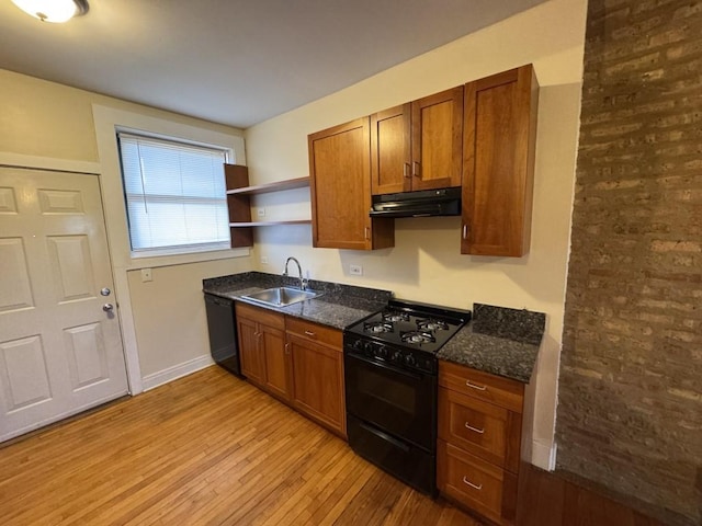 kitchen featuring dark stone countertops, sink, black appliances, and light hardwood / wood-style floors