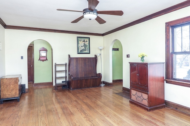 living room featuring ceiling fan, ornamental molding, and light hardwood / wood-style floors