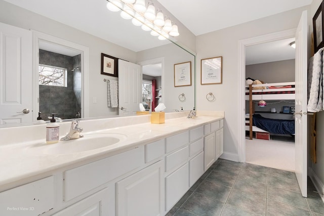 bathroom featuring tile patterned flooring, vanity, a healthy amount of sunlight, and walk in shower