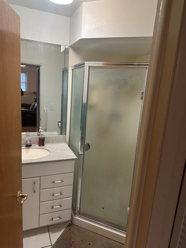 bathroom featuring tile patterned flooring, vanity, and walk in shower