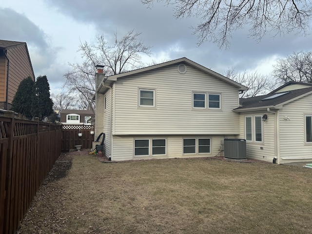 back of property featuring central AC unit and a lawn