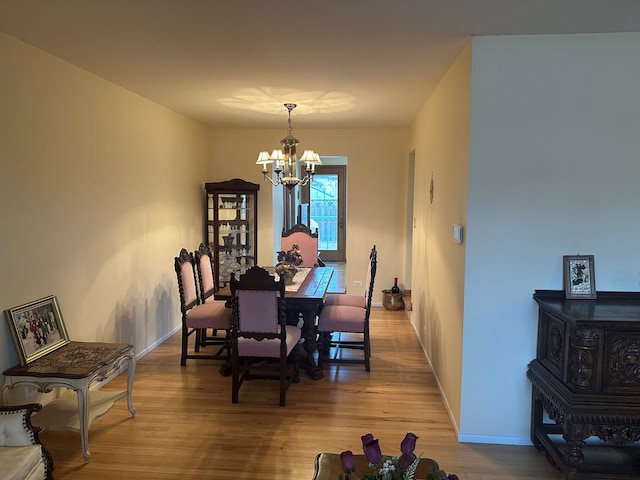 dining area with a notable chandelier and light hardwood / wood-style flooring