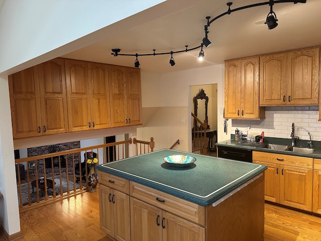 kitchen featuring a kitchen island, sink, decorative backsplash, and light hardwood / wood-style flooring