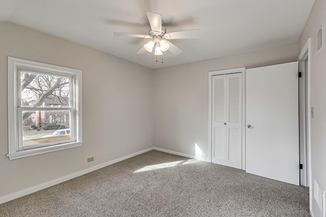 unfurnished bedroom with carpet flooring, ceiling fan, and a closet