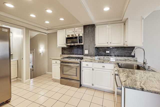 kitchen featuring sink, a tray ceiling, white cabinets, and appliances with stainless steel finishes