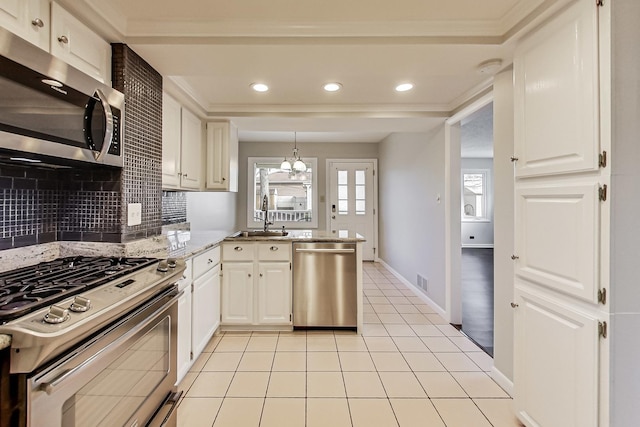 kitchen featuring sink, appliances with stainless steel finishes, kitchen peninsula, pendant lighting, and decorative backsplash