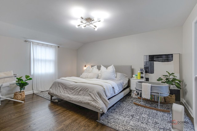 bedroom with lofted ceiling and dark hardwood / wood-style floors