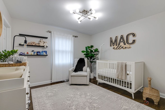 bedroom featuring a crib, wood-type flooring, and sink