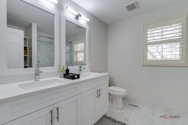 bathroom featuring vanity, toilet, and walk in shower