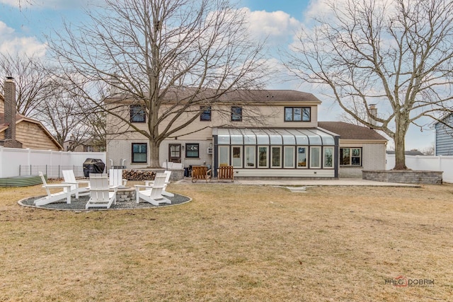 back of property featuring a fire pit, a yard, a patio area, and a sunroom