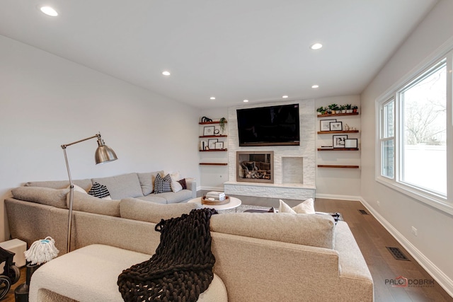 living room featuring dark wood-type flooring and a fireplace