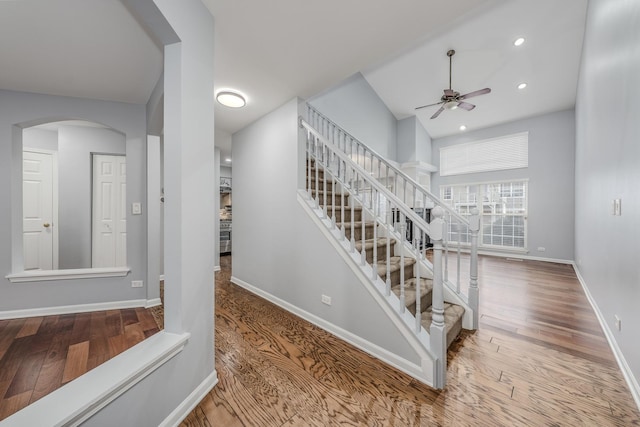 staircase featuring hardwood / wood-style floors and ceiling fan