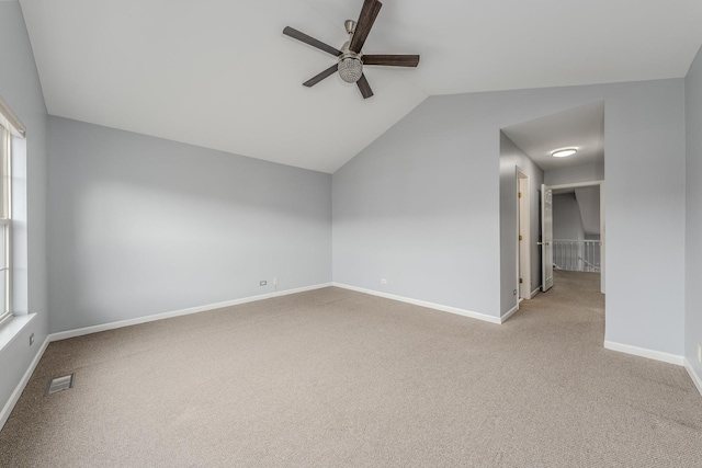 additional living space featuring vaulted ceiling, light colored carpet, and ceiling fan