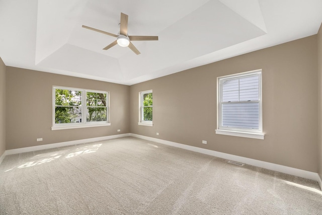 unfurnished room with carpet floors, ceiling fan, and a tray ceiling