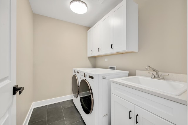 washroom featuring cabinets, sink, dark tile patterned flooring, and washer and clothes dryer