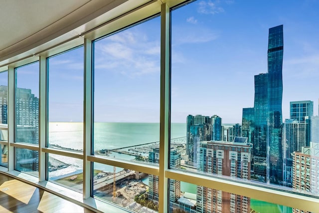 sunroom with a view of city and a water view