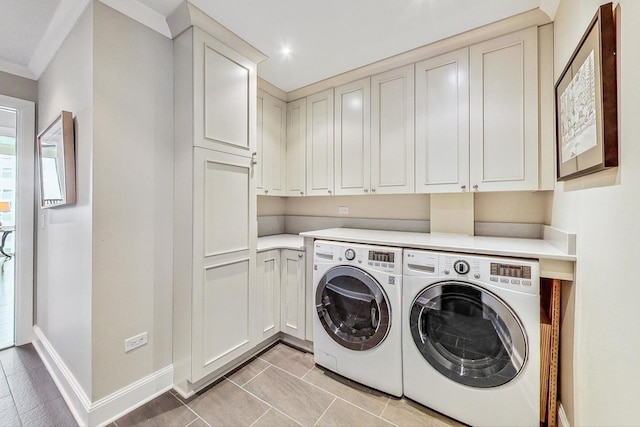 washroom featuring light tile patterned flooring, cabinet space, baseboards, and separate washer and dryer