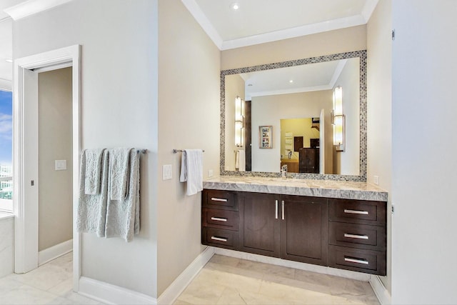 bathroom featuring baseboards, ornamental molding, and vanity