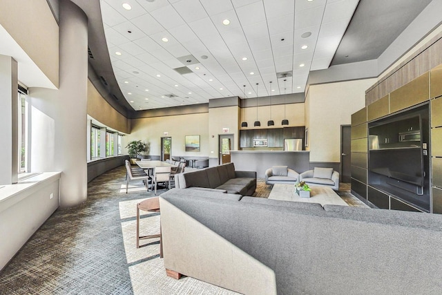 carpeted living area with recessed lighting and a towering ceiling