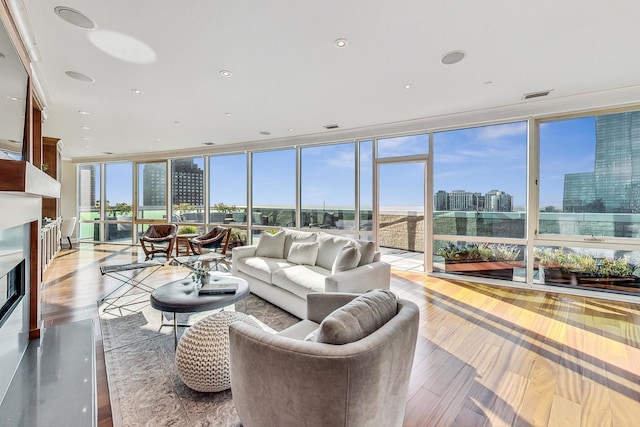 interior space featuring light wood-style flooring, expansive windows, visible vents, and a city view