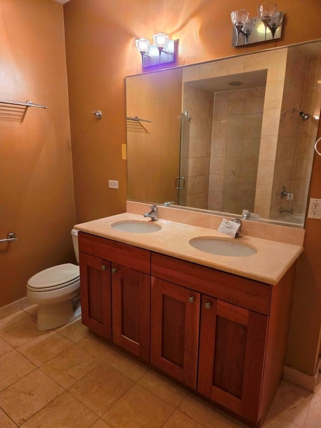 bathroom featuring a shower with door, vanity, tile patterned flooring, and toilet