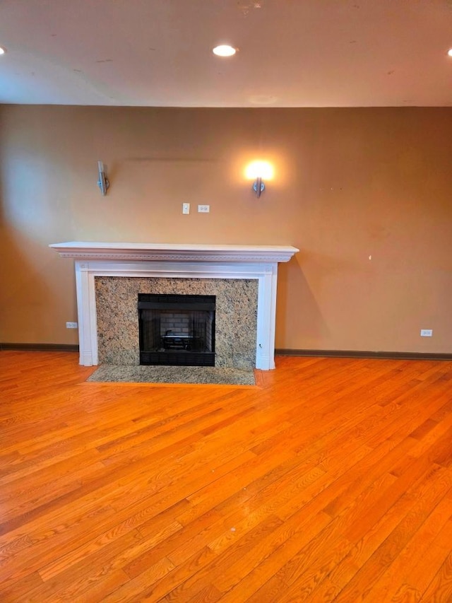 unfurnished living room with light hardwood / wood-style flooring and a high end fireplace