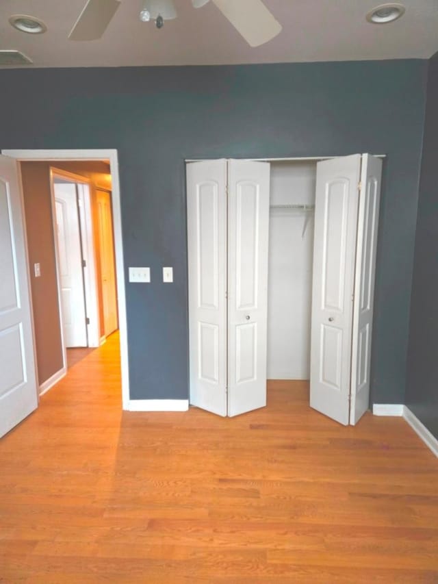 unfurnished bedroom featuring light hardwood / wood-style flooring, a closet, and ceiling fan