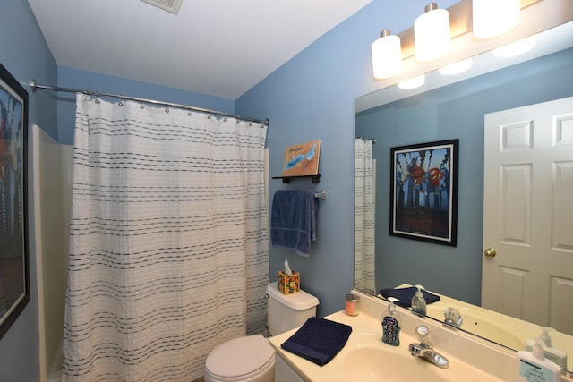 bathroom with vanity, toilet, and curtained shower