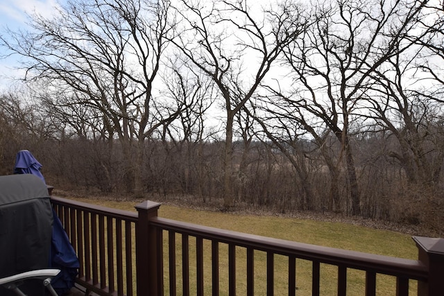 wooden terrace featuring a grill and a lawn