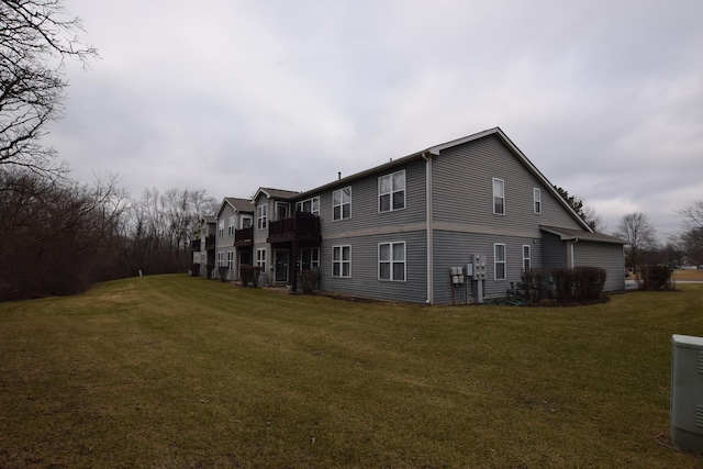 rear view of property with central AC and a yard