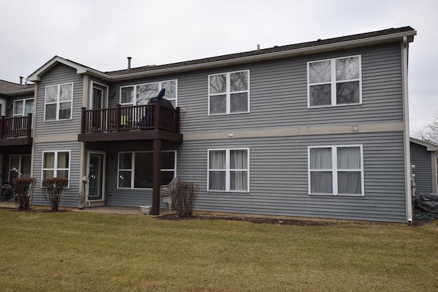 rear view of property featuring a lawn