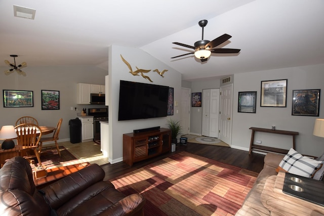 living room featuring hardwood / wood-style floors, vaulted ceiling, and ceiling fan