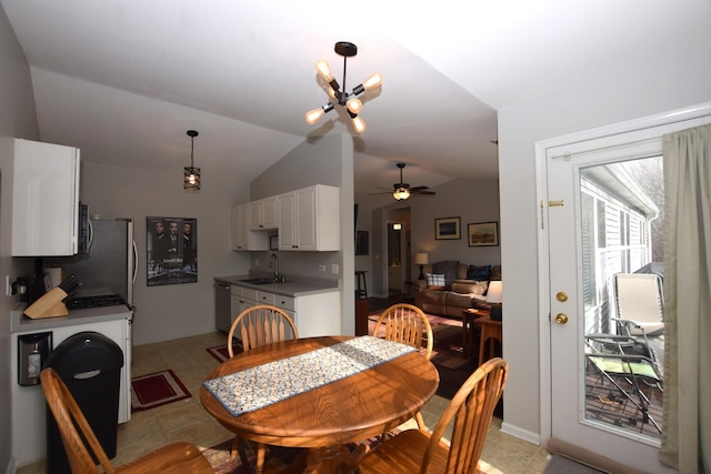 dining space with sink, vaulted ceiling, ceiling fan, and light tile patterned flooring