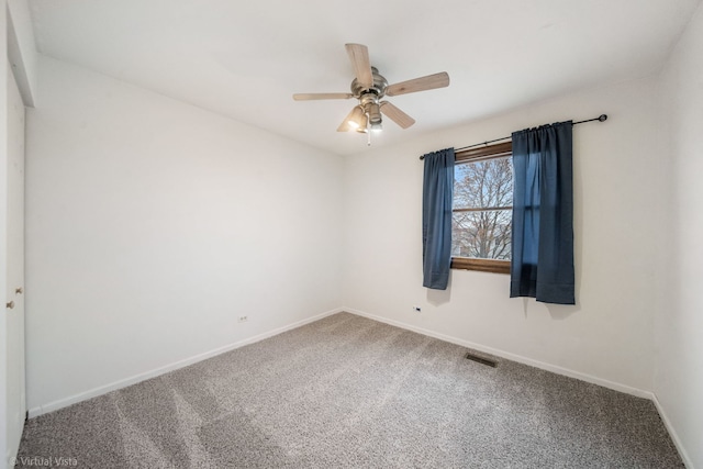 unfurnished room with ceiling fan and carpet